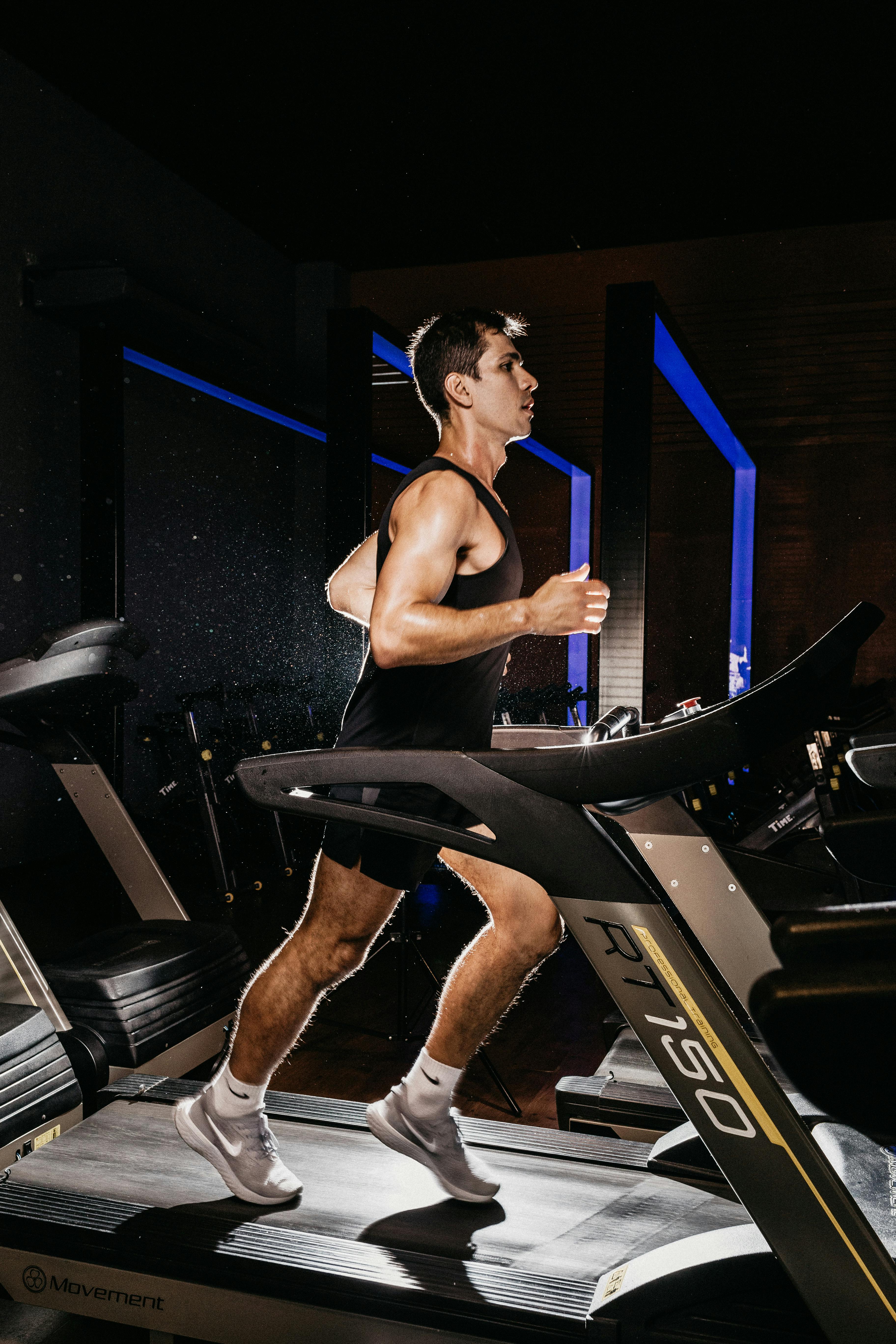 Man exercising on a treadmill indoors, showcasing fitness and determination.